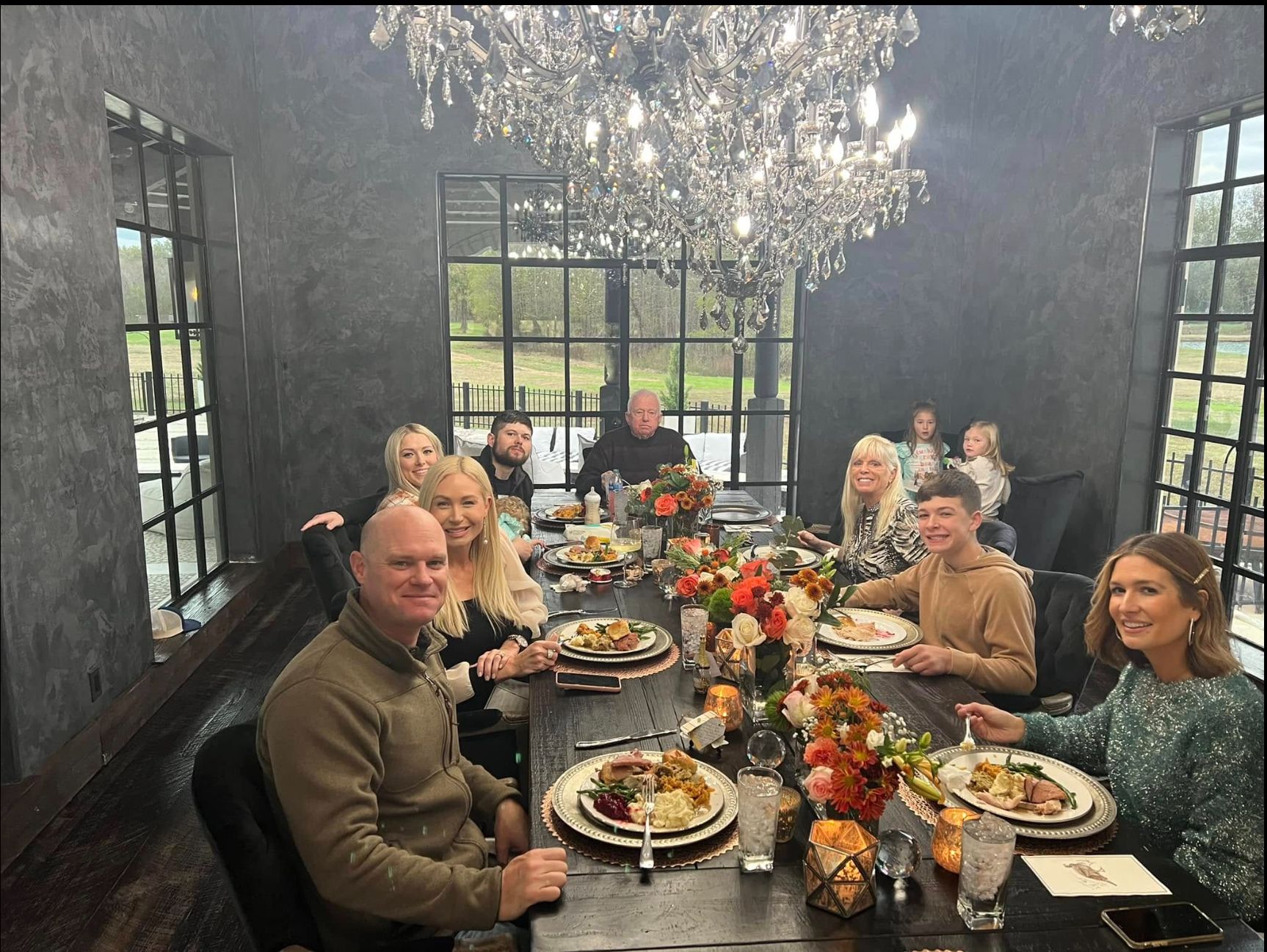 Guests seated for a private dinner under a chandelier, catered by Chef Rico